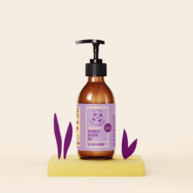 Intimate hygiene gel with oat and lavender in a brown pump bottle displayed on a yellow platform with purple leaves for skincare marketing.